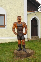 Socha zápasníka Gustava Frištenského v Kamhajku před jeho rodným domem